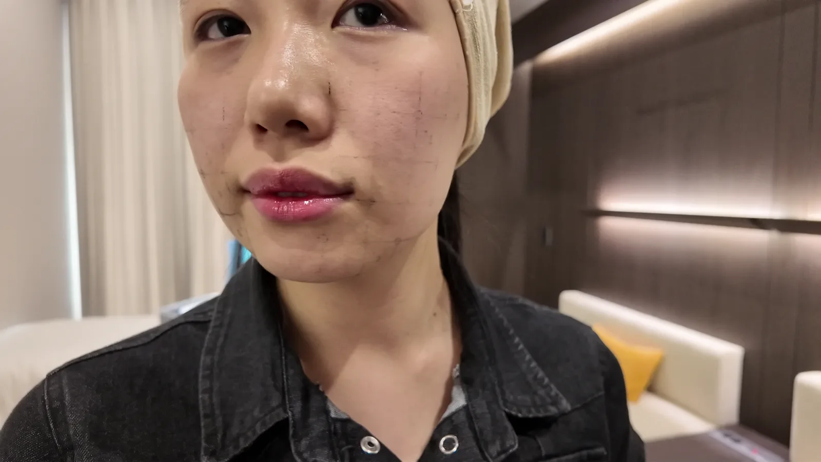 수건 헤어밴드를 한 사람의 얼굴 정면 가까이, 볼에 희미한 선이 그려져 있음